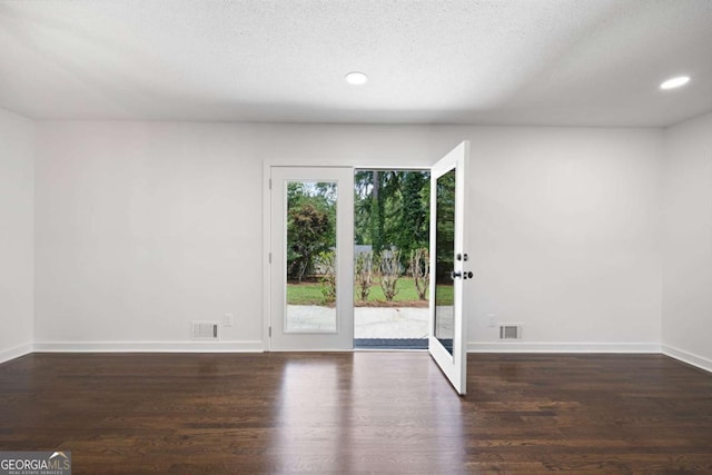 empty room with recessed lighting, wood finished floors, visible vents, and baseboards