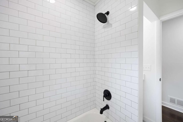 bathroom featuring washtub / shower combination and visible vents