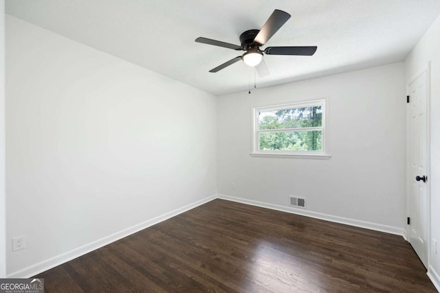 unfurnished room with visible vents, a ceiling fan, baseboards, and dark wood-style flooring