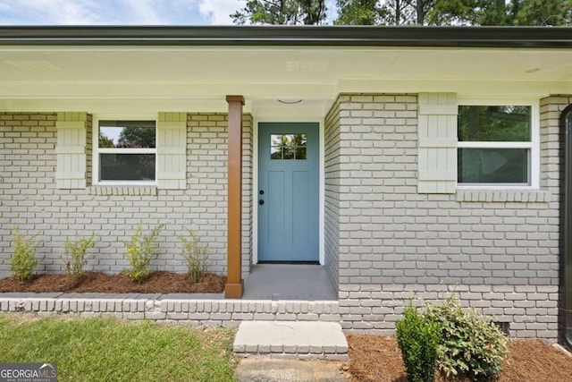 view of exterior entry with brick siding