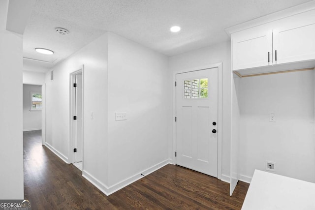 entrance foyer featuring dark wood-type flooring, baseboards, and a textured ceiling