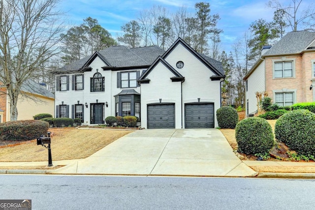 view of front of property featuring concrete driveway, a garage, and roof with shingles