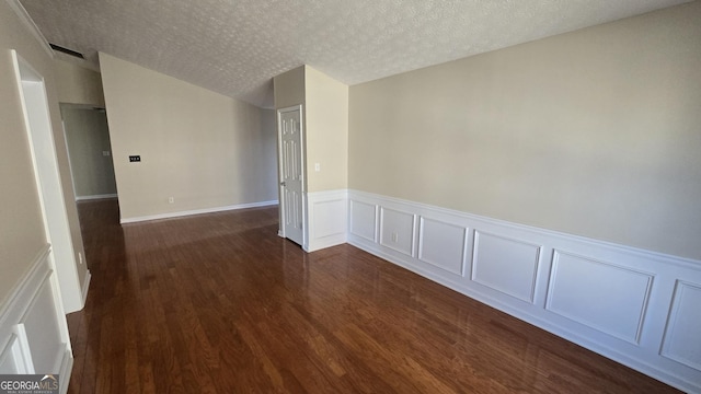 unfurnished room with dark wood-style floors and a textured ceiling