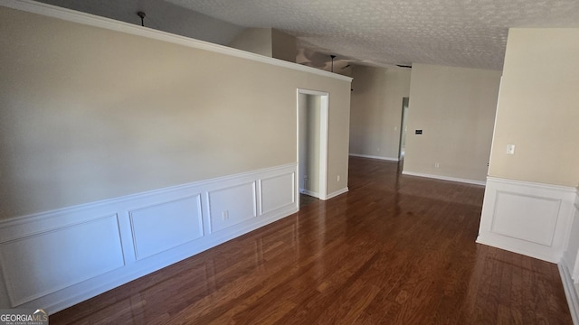 spare room featuring dark wood finished floors and a textured ceiling