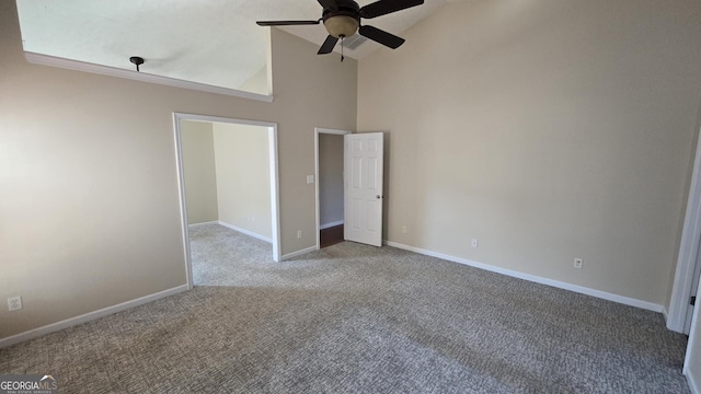 unfurnished bedroom featuring a ceiling fan, carpet, baseboards, and high vaulted ceiling