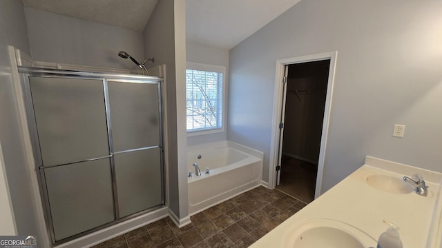 bathroom featuring a shower stall, a garden tub, lofted ceiling, and a sink