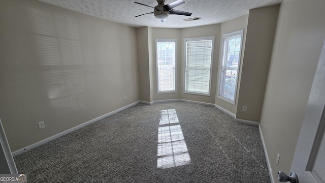 spare room with baseboards, carpet floors, and a textured ceiling