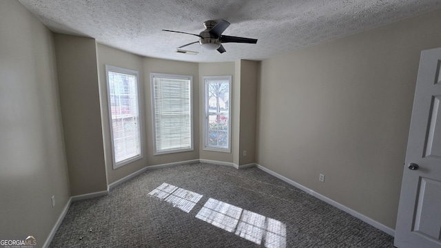 spare room with baseboards, carpet floors, a textured ceiling, and ceiling fan