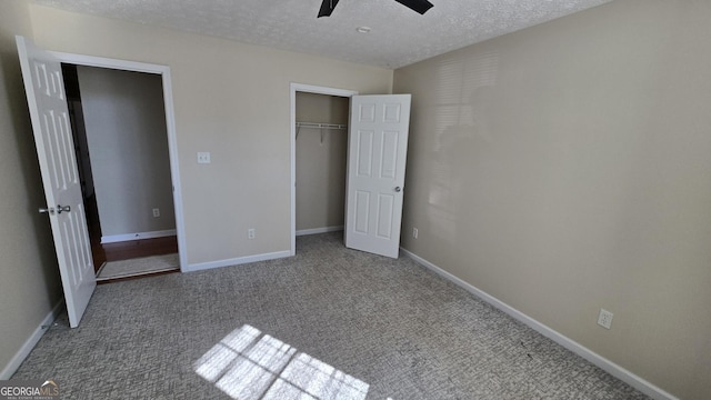 unfurnished bedroom featuring baseboards, ceiling fan, a closet, a textured ceiling, and carpet flooring