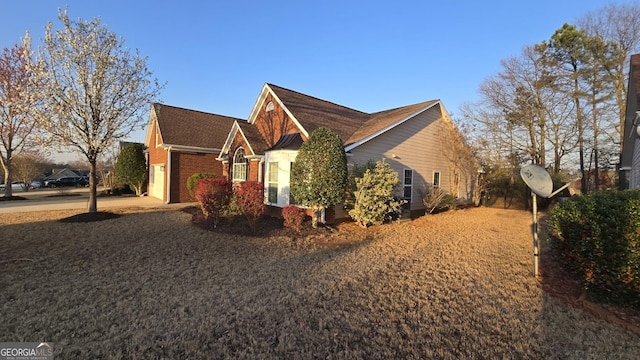 view of side of home with concrete driveway and brick siding