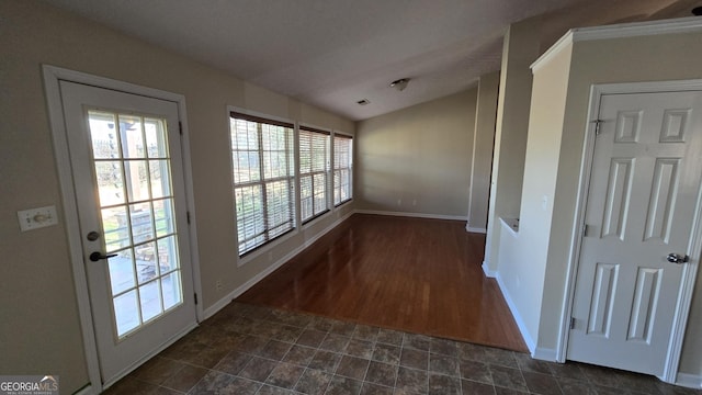 interior space featuring baseboards and vaulted ceiling