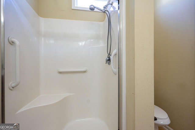 bathroom with toilet and a shower stall