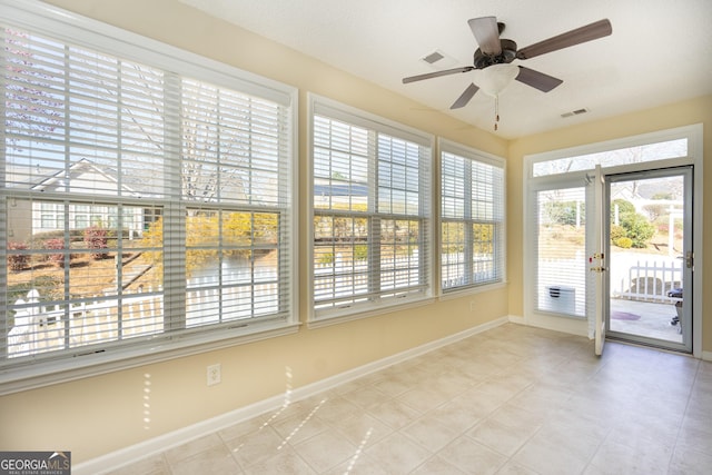 unfurnished sunroom featuring visible vents and ceiling fan