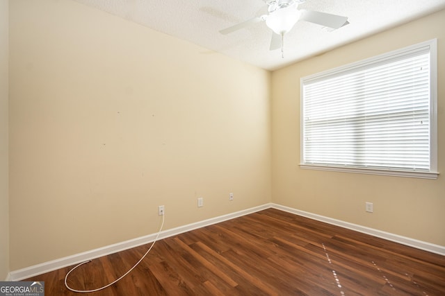 spare room featuring baseboards, a textured ceiling, ceiling fan, and dark wood-style flooring