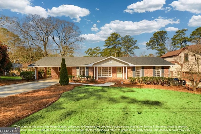 view of front of property featuring brick siding, an attached carport, concrete driveway, and a front yard