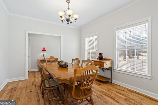 dining room featuring crown molding, light wood-style flooring, a notable chandelier, and baseboards