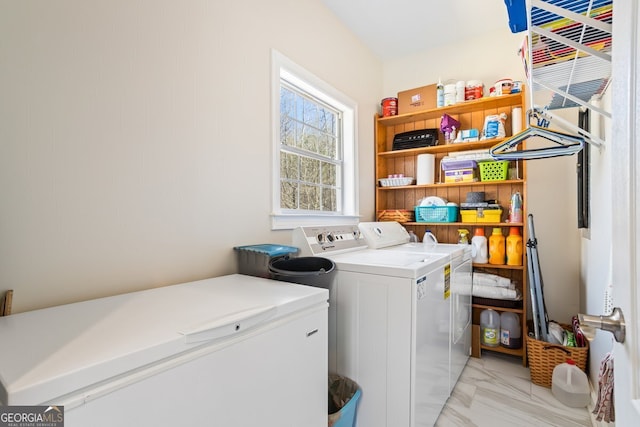 clothes washing area featuring laundry area, marble finish floor, and washer and clothes dryer