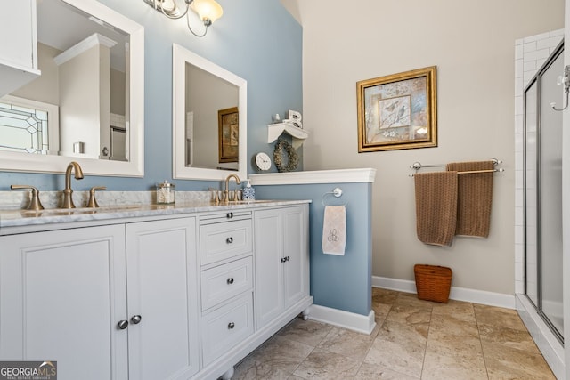 bathroom featuring a sink, baseboards, tiled shower, and double vanity