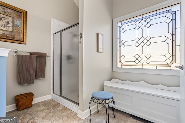 bathroom featuring a stall shower and baseboards