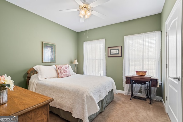 bedroom with multiple windows, light carpet, baseboards, and ceiling fan