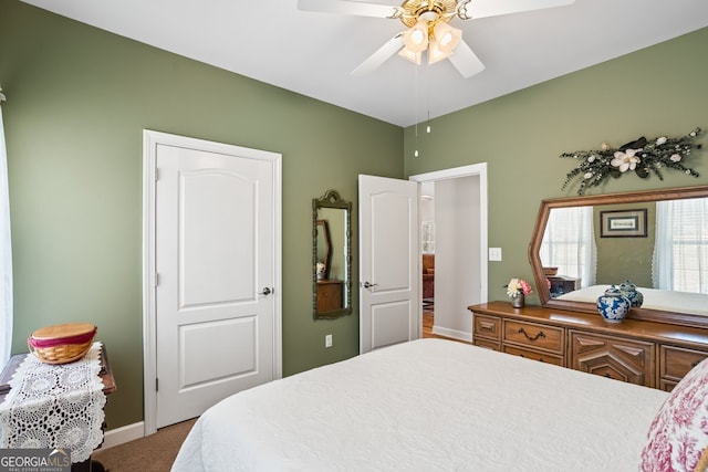 bedroom with a ceiling fan, baseboards, and carpet floors