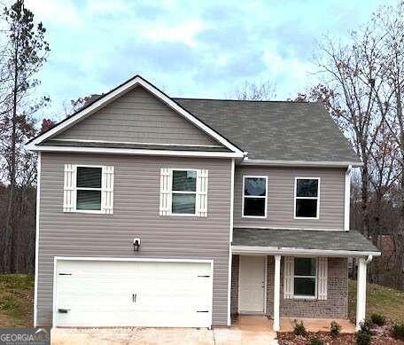 view of front of property featuring a porch, driveway, and a garage