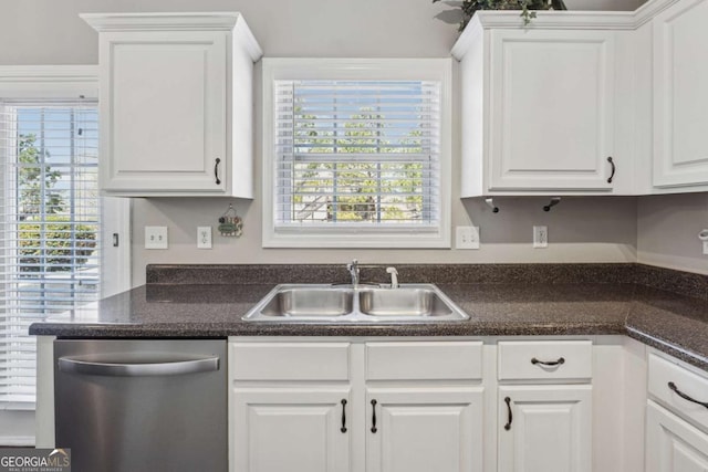 2311 Fall Creek Lndg, Loganville, GA 30052 - kitchen with stainless steel dishwasher, white cabinets, dark countertops, and plenty of natural light