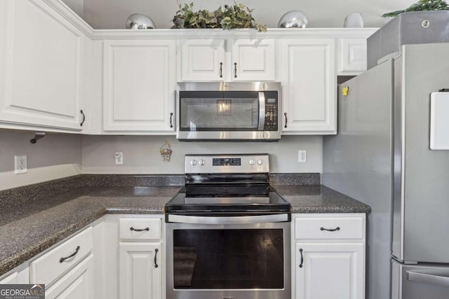2311 Fall Creek Lndg, Loganville, GA 30052 - kitchen with appliances with stainless steel finishes, white cabinetry, and dark stone countertops