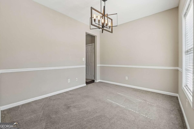 unfurnished dining area featuring carpet, baseboards, a wealth of natural light, and a chandelier