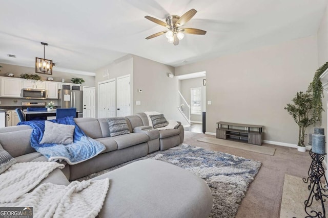 2311 Fall Creek Lndg, Loganville, GA 30052 - living room with light carpet, ceiling fan, and stairs