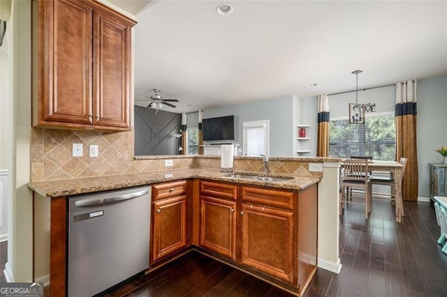 kitchen featuring brown cabinets, a sink, stainless steel dishwasher, a peninsula, and light stone countertops