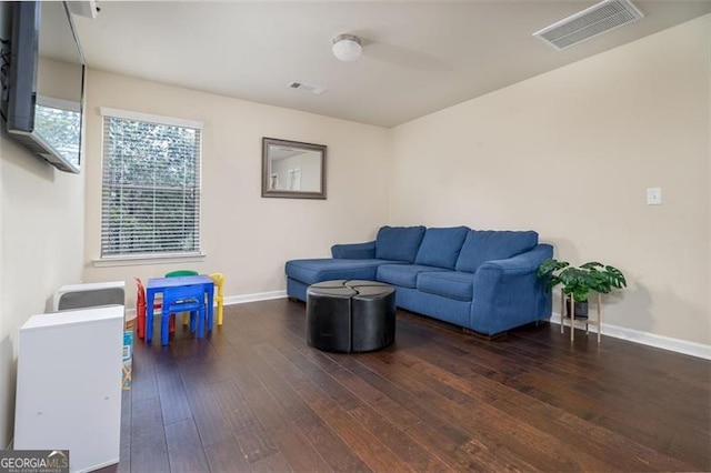 living area featuring visible vents, baseboards, and hardwood / wood-style floors