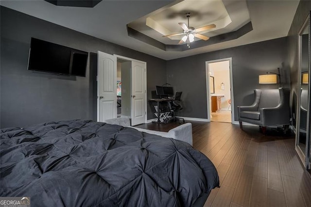 784 Sunset Down Ct, Loganville, GA 30052 - bedroom featuring a raised ceiling, wood finished floors, ensuite bath, ceiling fan, and an office area