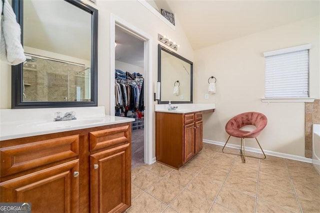 full bathroom featuring a walk in closet, two vanities, a shower stall, tile patterned flooring, and lofted ceiling