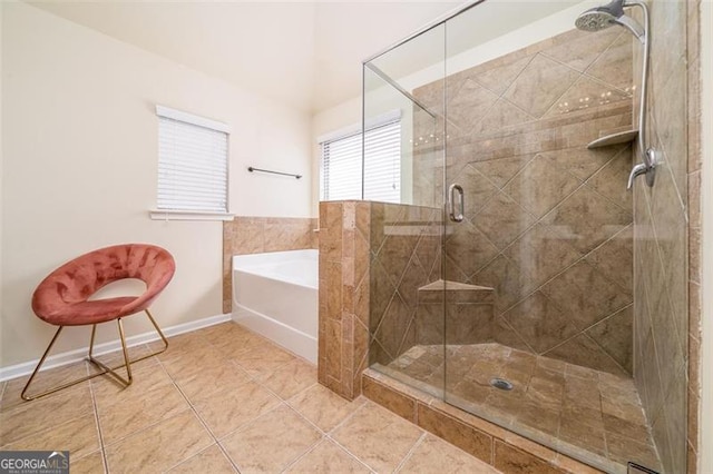 bathroom featuring a garden tub, a shower stall, and tile patterned flooring