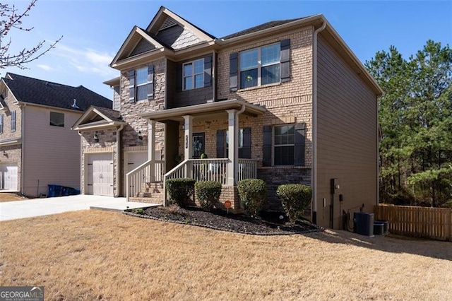 craftsman inspired home with brick siding, a porch, central AC, a garage, and driveway