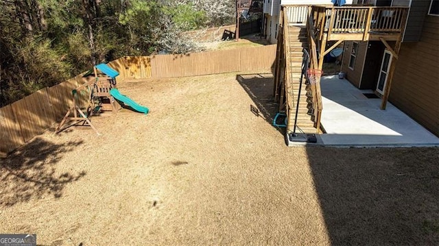 view of yard featuring a patio area, a playground, and a fenced backyard