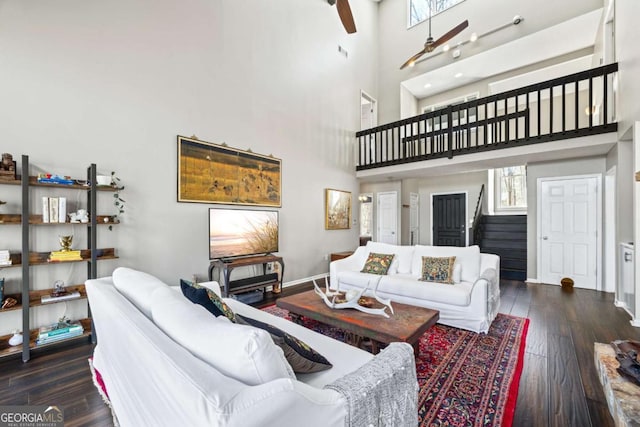 living area featuring a healthy amount of sunlight, stairs, baseboards, and hardwood / wood-style flooring