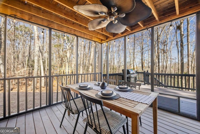 sunroom / solarium with plenty of natural light, wood ceiling, and a ceiling fan