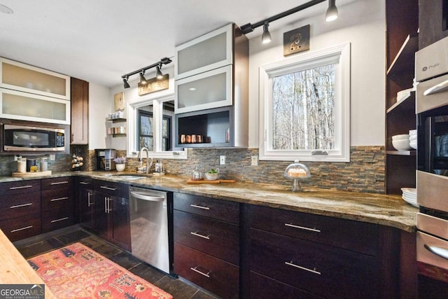 kitchen with light stone counters, open shelves, a sink, decorative backsplash, and appliances with stainless steel finishes