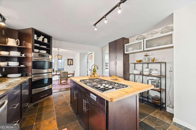 kitchen with open shelves, stone tile flooring, appliances with stainless steel finishes, wooden counters, and dark brown cabinets