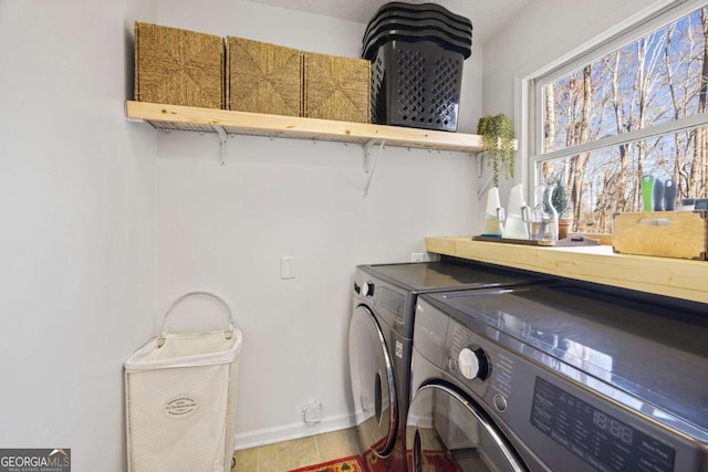 clothes washing area featuring washer and clothes dryer, laundry area, and baseboards