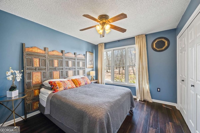 bedroom with a closet, baseboards, a textured ceiling, and hardwood / wood-style flooring