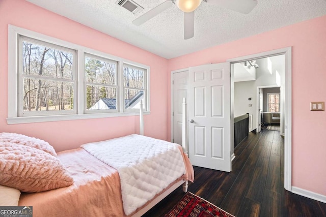 bedroom with visible vents, multiple windows, dark wood-type flooring, and a textured ceiling