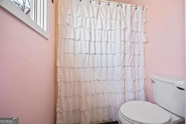 bathroom with a shower with curtain and toilet