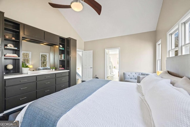 bedroom with high vaulted ceiling, ensuite bathroom, and a ceiling fan