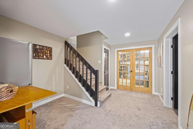 carpeted foyer with french doors, stairs, and baseboards