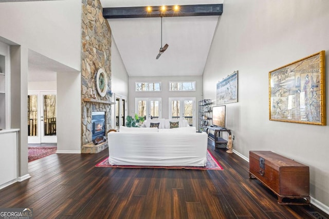 interior space featuring baseboards, wood-type flooring, high vaulted ceiling, and a fireplace