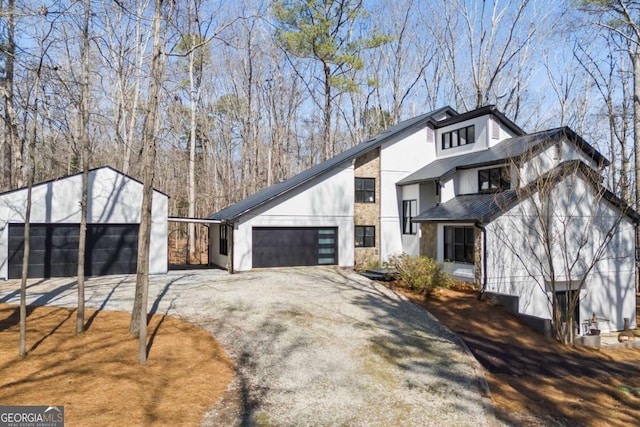 view of side of home with stucco siding, driveway, and a garage