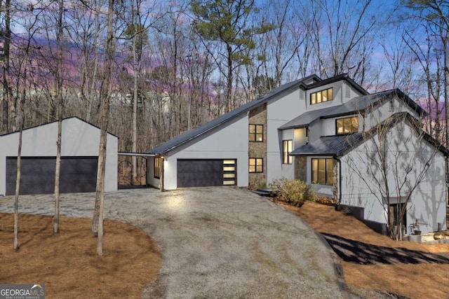 view of front facade featuring stucco siding, driveway, and an attached garage